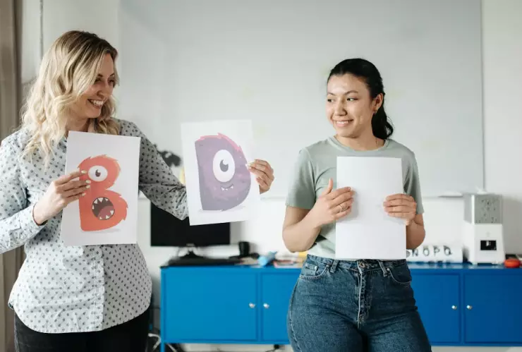 Una maestra, residente de Estados Unidos y una profesora latina dando clases.