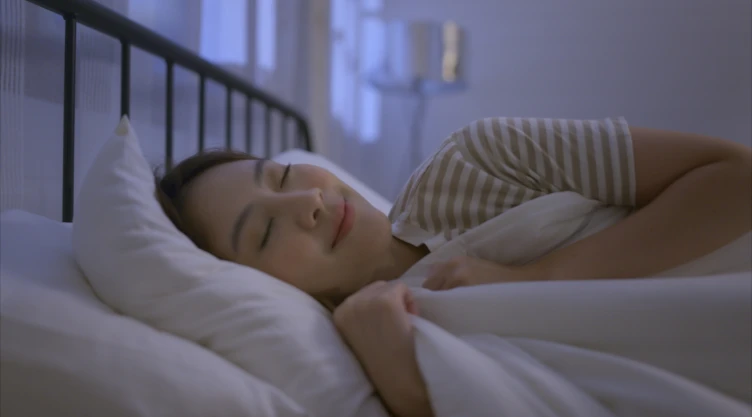 Una mujer duerme plácidamente en su cama.
