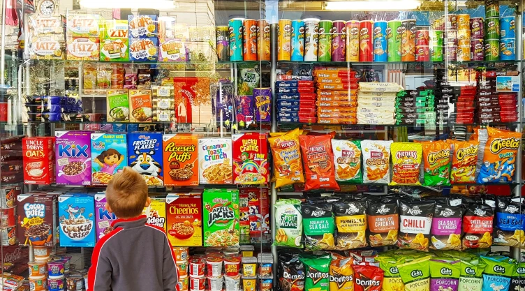 Un niño mira golosinas y otros productos en el supermercado