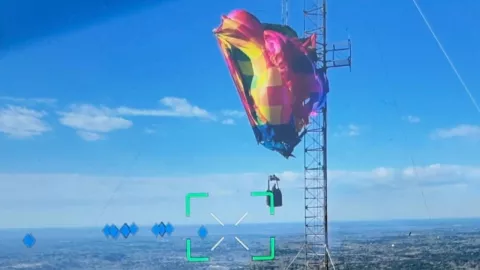 Globo quedó atorado en torre en Texas; dos personas pasaron cinco horas a 280 metros antes de ser rescatadas.