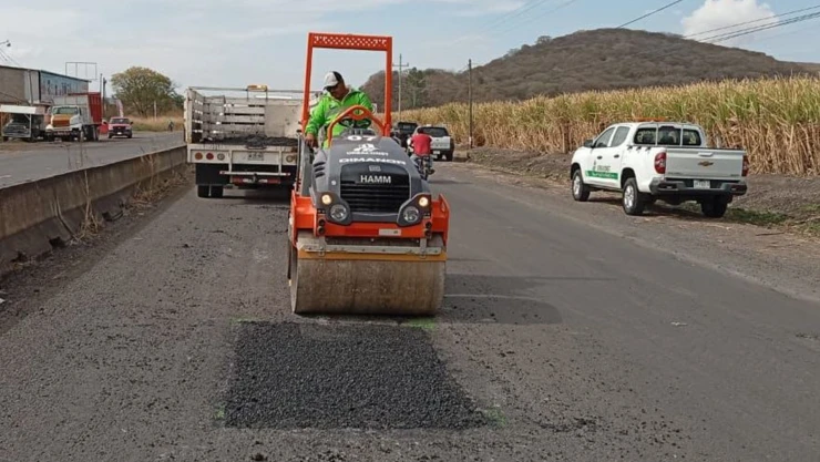 Hombre a bordo de una aplanadora realizando bacheo en una carretera de Jalisco