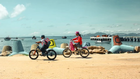 Estudiantes dan un paseo en bicicleta a la orilla de la playa.