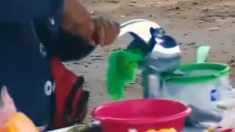 mujer exprime trapo con jugo de naranja