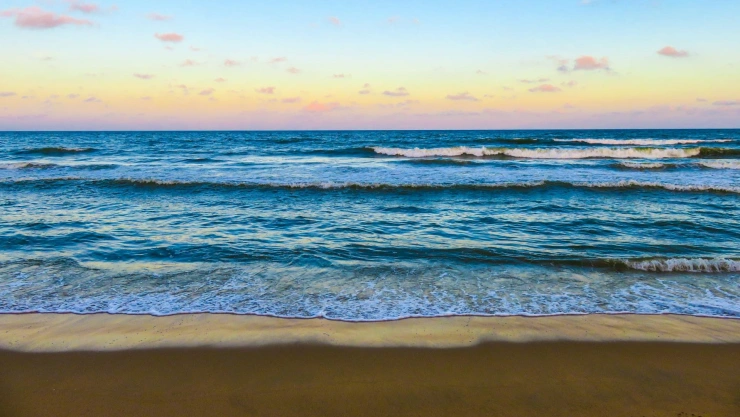 Atardecer en una playa con oleaje