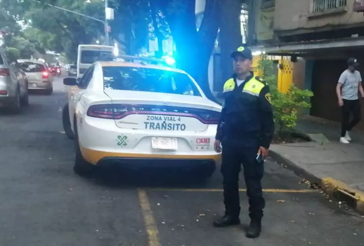 oficila de tránsito junto a su patrulla