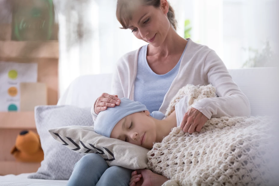 Weak girl with headscarf sleeping on mother’s knees at home
