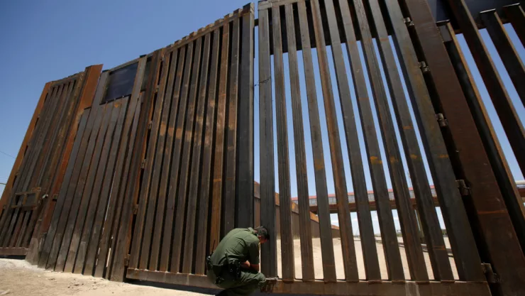A U.S. Border Patrol Agent closes one section of the border fence between U.S.-Mexico in El Paso