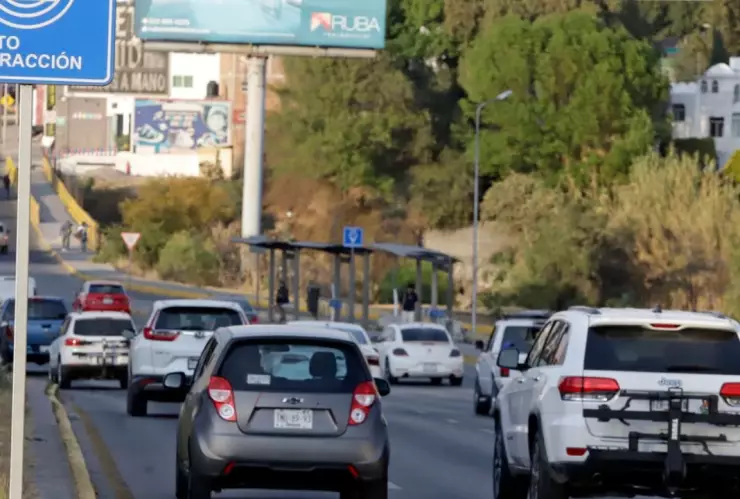 Carros transitando por una autopita con imagen de fondo sobre las fotoinfracciones en Puebla
