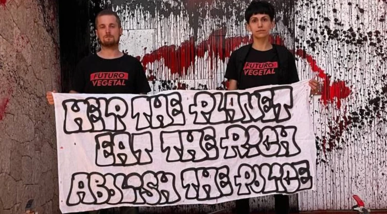 Dos integrantes del grupo Futuro Vegetal, enseñan cartel de protesta frente a la casa de Messi en Ibiza