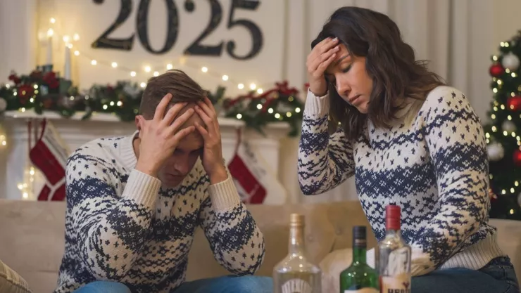 un hombre y una mujer con dolor de cabeza por resaca de Año Nuevo