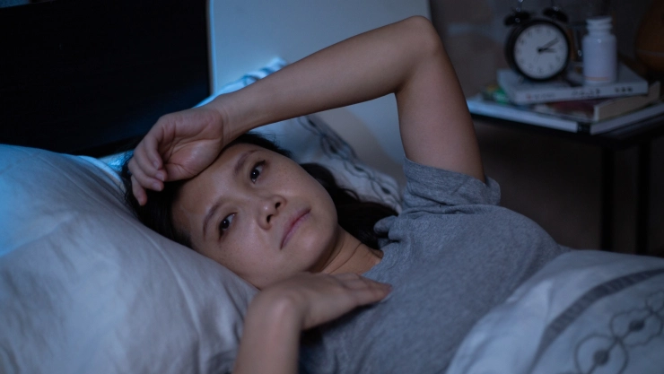 Una mujer despierta en su cama a las 3 am.