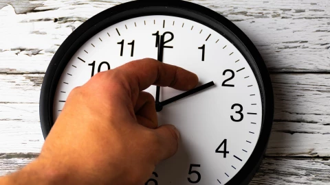 Hombre ajusta las manecillas de un reloj