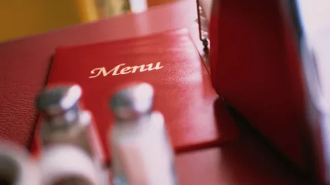 menú a lado de la un bote de sal y pimienta