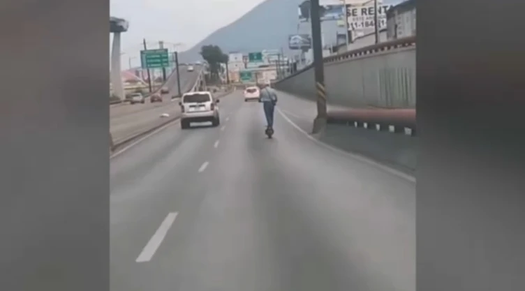 Hombre en “scooter” viaja por vialidades transitadas de Monterrey.