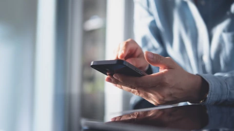 Un hombre revisa su celular.