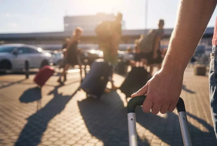 un hombre lleva su maleta al aeropuerto