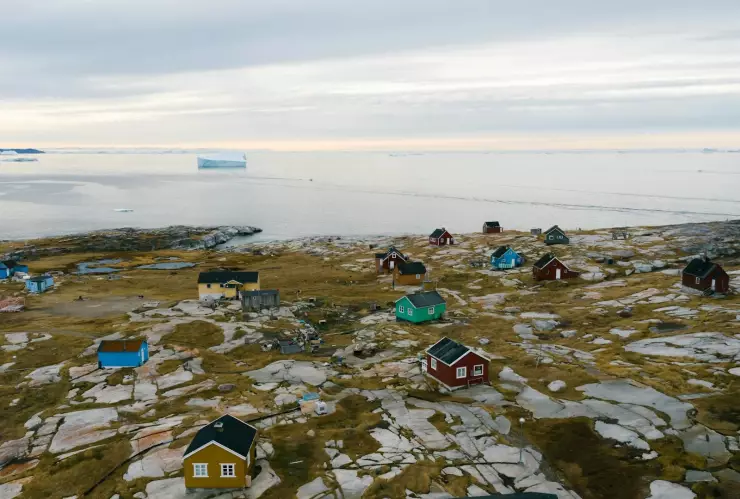 Panorámica del pueblo de Tiniteqilaaq, Groenlandia. Al fondo se ve un iceberg en el mar