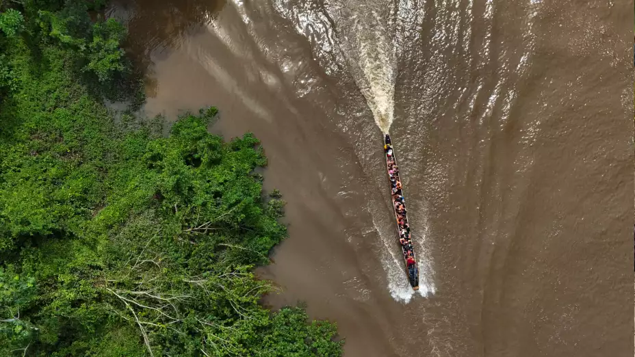 Migrantes en una embarcación tras cruzar a pie el Tapón del Darién.
