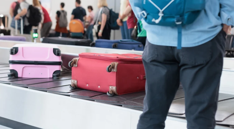 un usuario esperando su maleta en un aeropuerto.