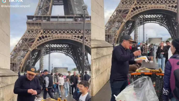 Hombre vende elotes en Torre Eiffel
