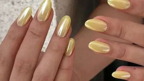 El acabado velvet proporciona brillo y textura a las uñas amarillo mantequilla