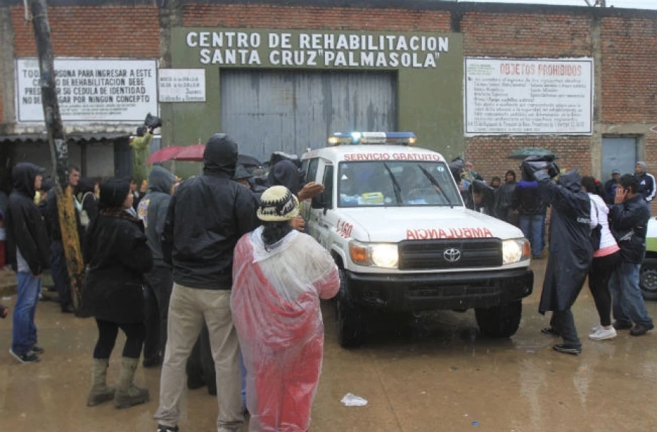 Familiares de presos y periodistas rodean una ambulancia que abandona la prisión de Palmasola en Santa Cruz, Bolivia