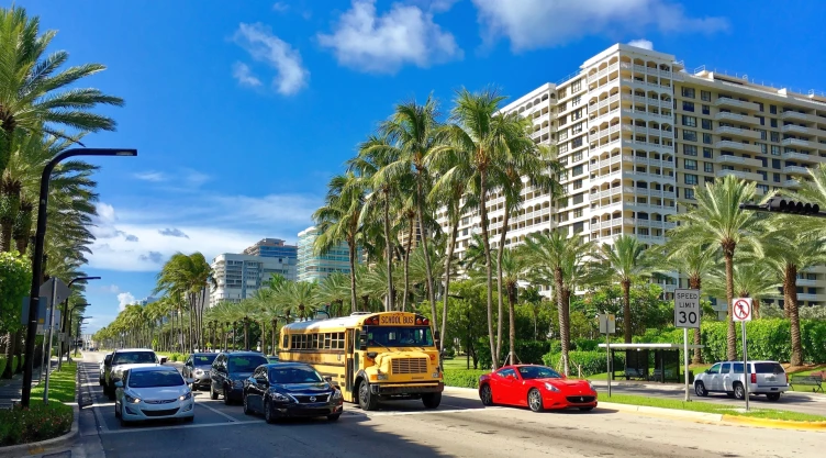Una calle de Miami con coches y un autobús escolar.