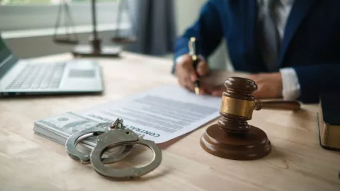 Un abogado firma una denuncia de fraude.