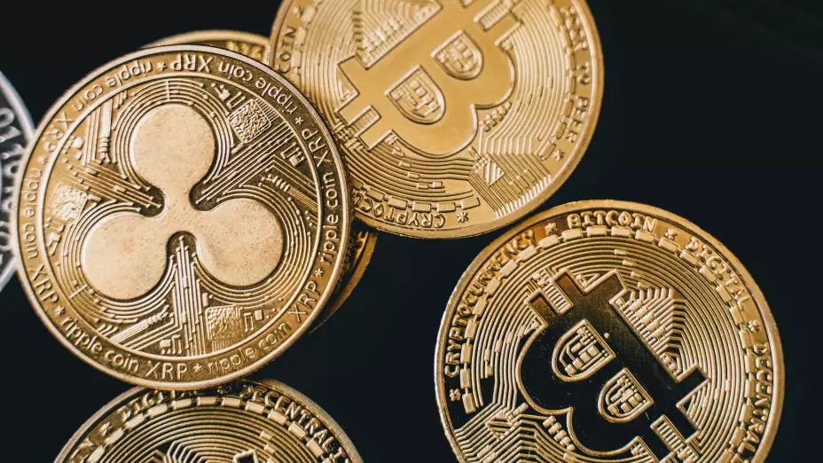 5 claves que debes tener en cuenta al invertir en criptomonedas para no perder dinero. En la imagen se observa dos mondas de oro que hacen referencia a las poderosas criptomonedas de Bitcoin y XRP de Ripple.