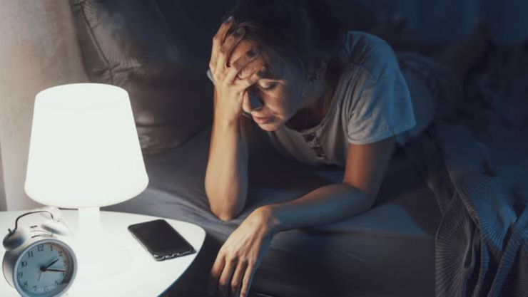 Una persona que no puede dormir bien durante la noche y con una lámpara encendida