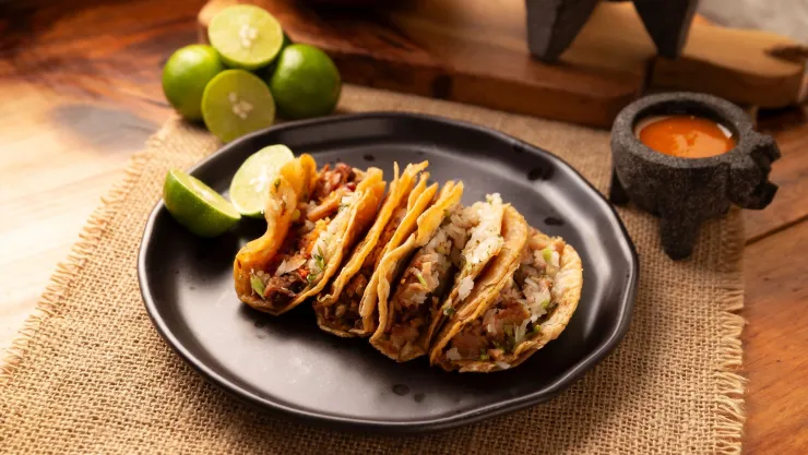 Un plato con cuatro tacos.