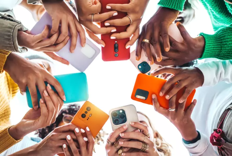 Un círculo formado por personas que sostienen teléfonos en sus manos