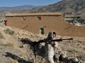 Un niño afgano lleva un arma en la zona afectada por el terremoto de la aldea de Wor Kali, en la provincia de Paktika, Afganistán.