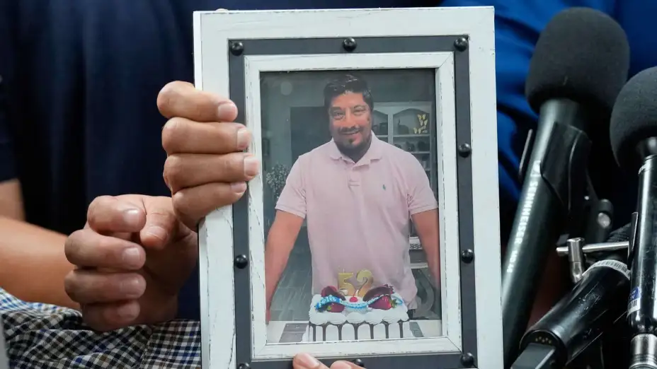 Hijos de Lorenzo Salgado Araujo sostienen una fotografía de su padre.