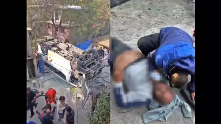 Combi volteada y que cayó a barranca en Nicolás Romero, Estado de México; a un lado está el conductor de la unidad que resultó lesionado.