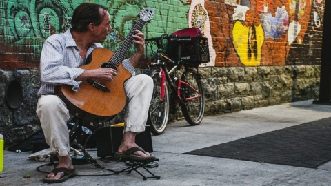 ¿Se necesita permiso para cantar en calles? Locatario corre a músico a cubetazos de agua y gremio musical lo defiende