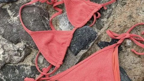 Un bikini coral hace brillar la piel morena