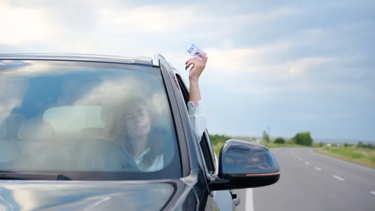 Una mujer enseña su licencia de conducir.