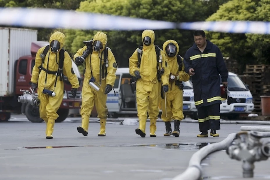 omberos con trajes de protección química ingresan en un área restringida después de una filtración de amoníaco en una planta frigorífica en Shanghai
