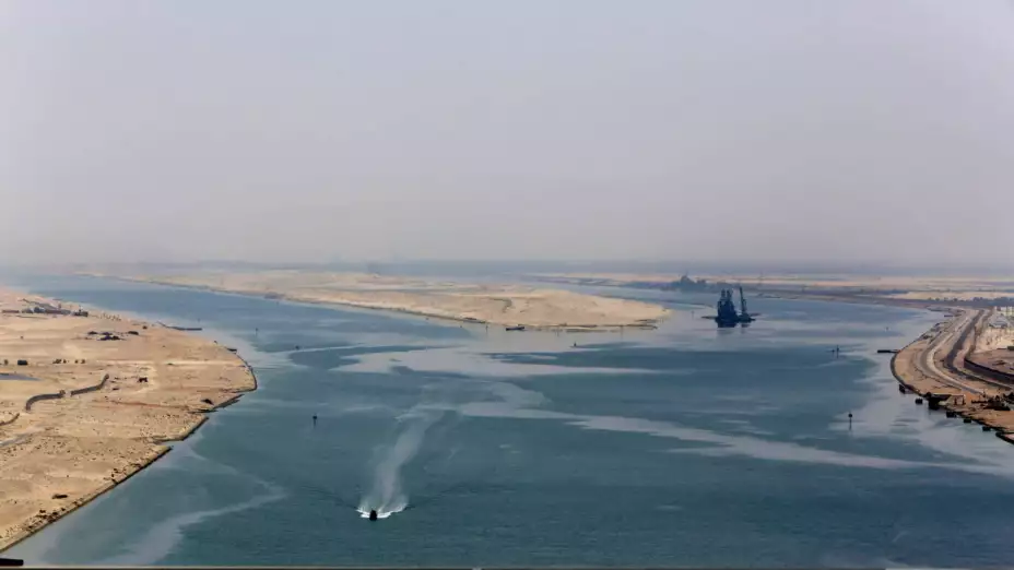 Embarcación militar vigila una nueva sección del canal de Suez, en Egipto.
