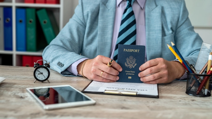 Un funcionario con un formulario de visa y el pasaporte estadounidense.