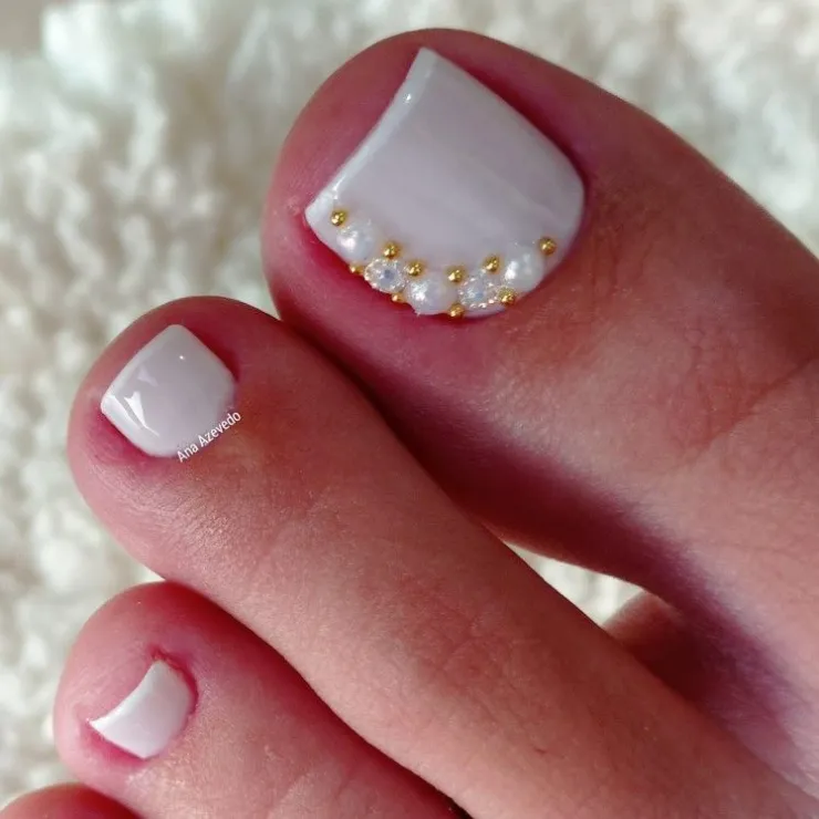 9 diseños de uñas blancas con dorado que puedes usar en los pies para lucir en natación