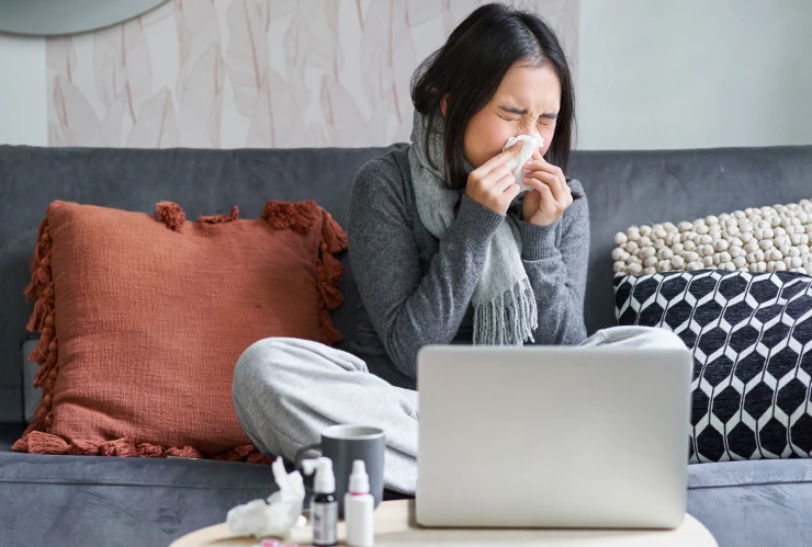 Una mujer resfriada en su casa