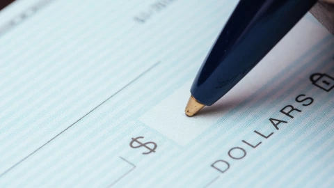 Una persona firma un cheque estadounidense