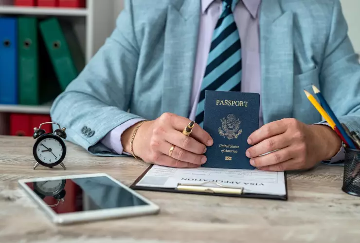 Un funcionario con un formulario de visa y el pasaporte estadounidense.