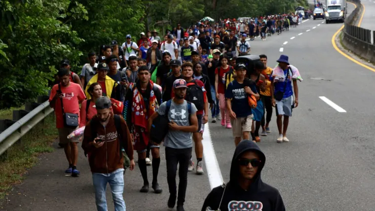 Migrantes caminando para dirigirse al norte de la frontera.