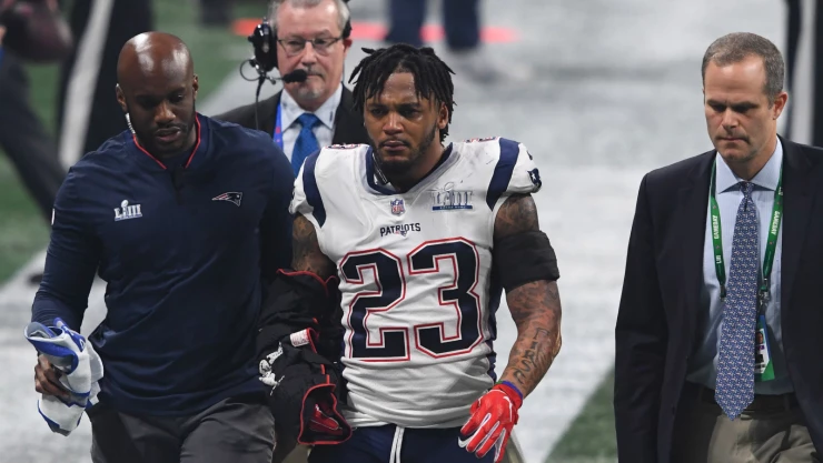 Patrick Chung es escoltado fuera del campo luego de sufrir una lesión aparente durante el tercer cuarto del Super Bowl LIII
