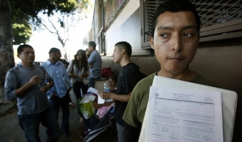 Migrantes esperan afuera de la oficina de deportaciones