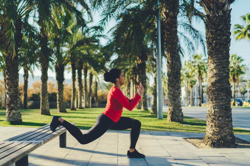 mujer haciendo un desplante en una banca ejercicio al aire libre