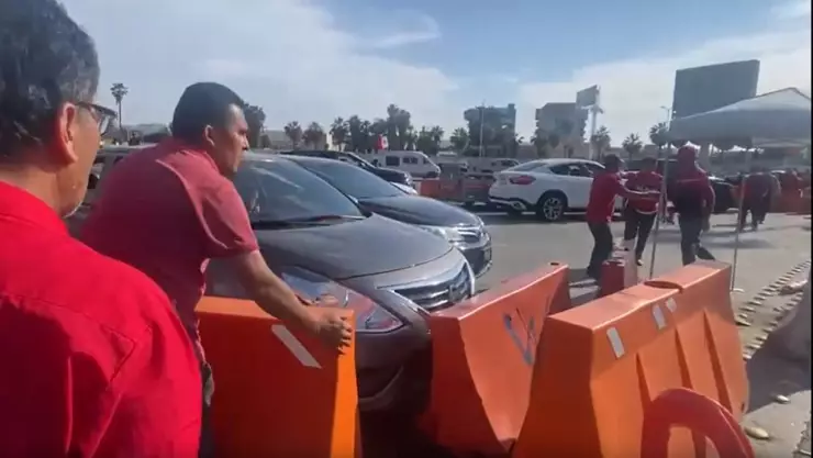 VIDEO: Momento en que conductores de taxis rojos bloquean la garita